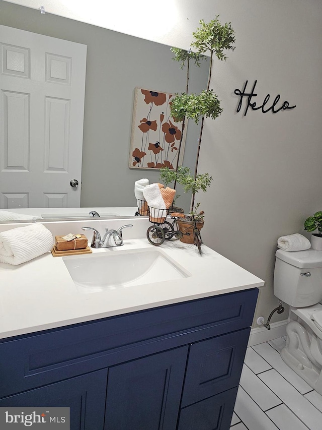 bathroom with tile patterned flooring, vanity, and toilet