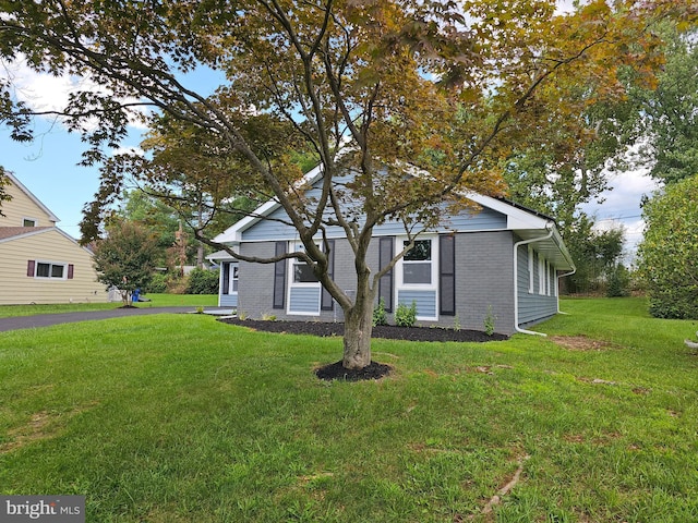 view of front of property with a front lawn and brick siding