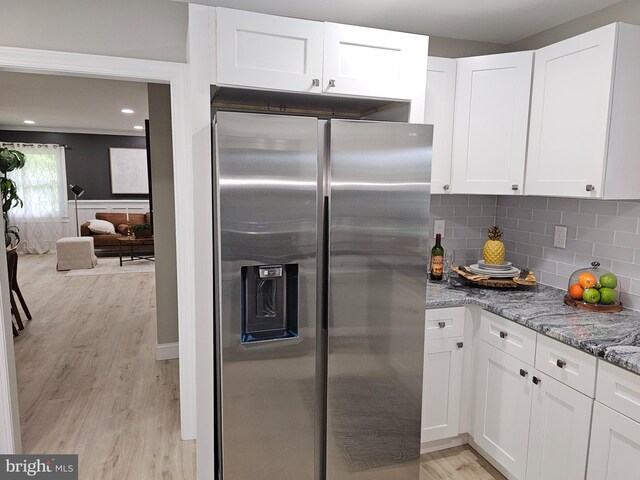 kitchen featuring light hardwood / wood-style flooring, backsplash, stainless steel refrigerator with ice dispenser, white cabinetry, and light stone counters