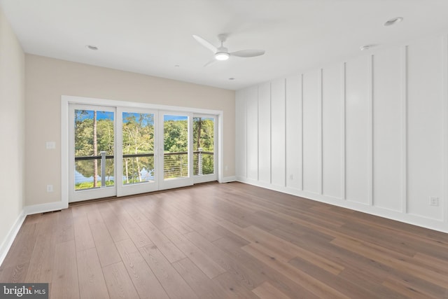 empty room with hardwood / wood-style floors and ceiling fan