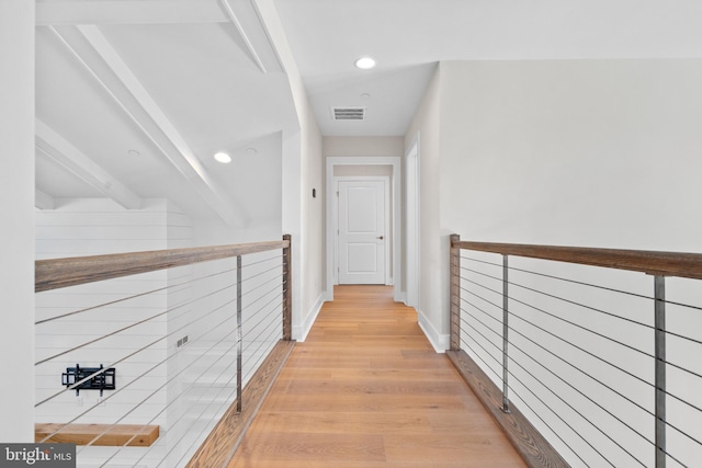 hall with beamed ceiling and light hardwood / wood-style floors