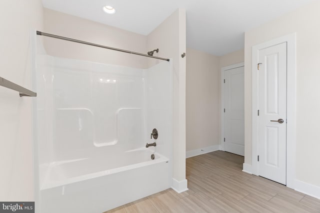 bathroom with shower / washtub combination and baseboards