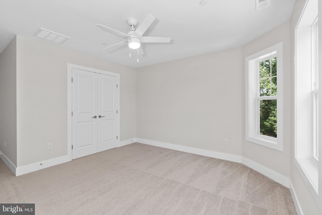 spare room featuring ceiling fan and light colored carpet