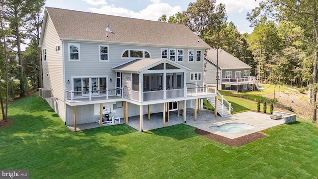 back of house featuring a deck, a patio, a lawn, a sunroom, and a hot tub