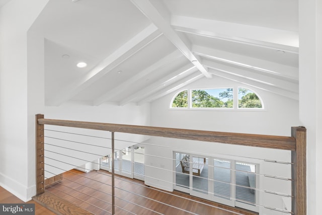 additional living space with vaulted ceiling with beams and wood-type flooring