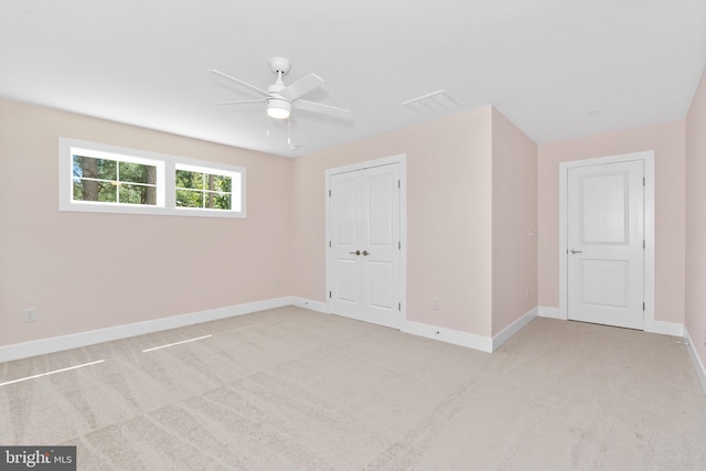 carpeted spare room featuring ceiling fan