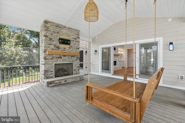 wooden deck featuring an outdoor stone fireplace