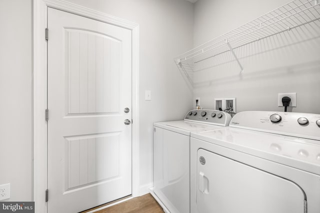 laundry room featuring light wood-type flooring, separate washer and dryer, and laundry area