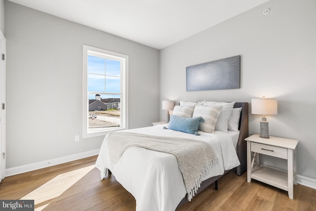 bedroom with baseboards and wood finished floors