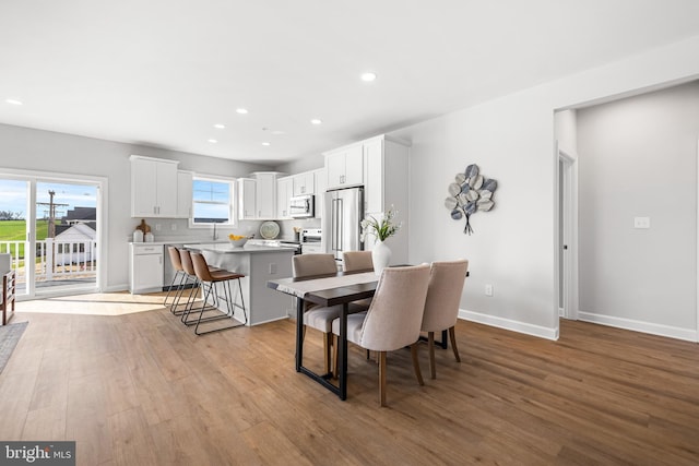 dining area with recessed lighting, baseboards, and light wood-style flooring