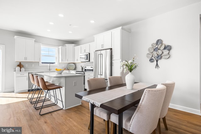 dining space featuring recessed lighting, light wood-type flooring, and baseboards