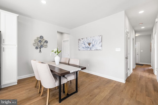 dining space with light wood-style flooring, recessed lighting, and baseboards