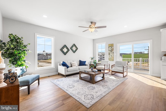 living room with baseboards, recessed lighting, light wood-type flooring, and ceiling fan