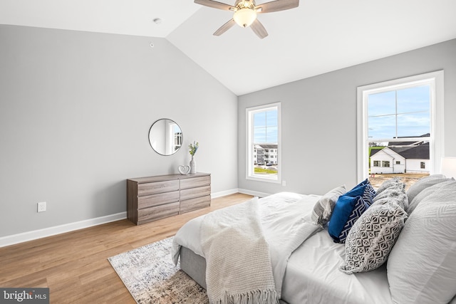 bedroom with baseboards, a ceiling fan, vaulted ceiling, and light wood finished floors