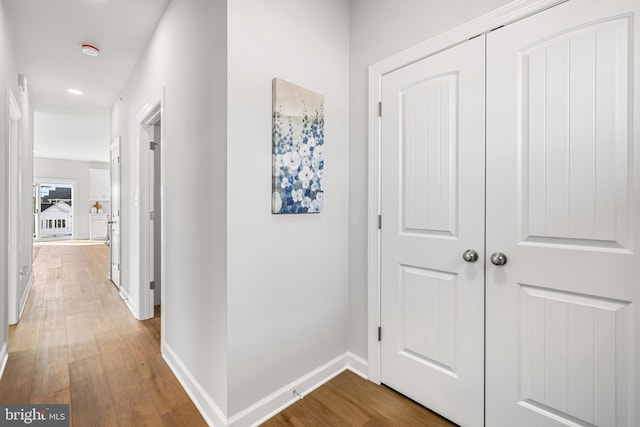 hall with baseboards and wood finished floors