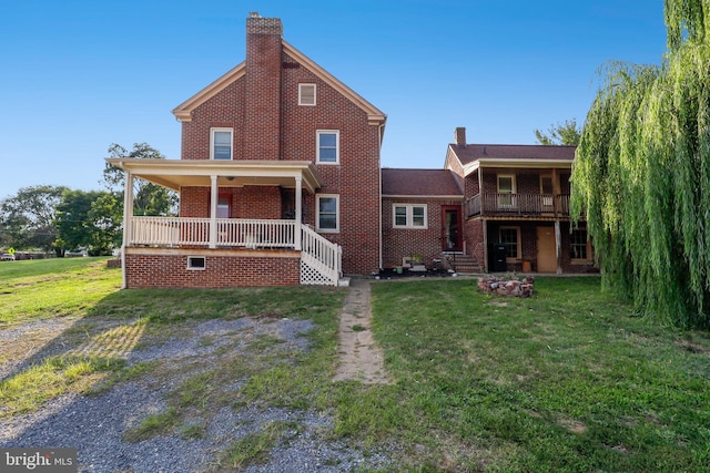 rear view of property featuring a lawn