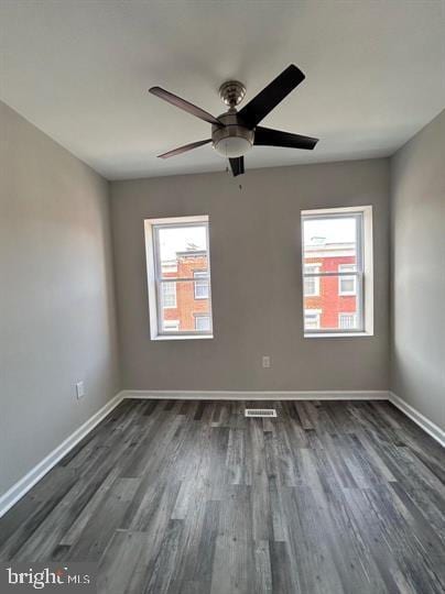 unfurnished room featuring dark wood-type flooring, ceiling fan, and plenty of natural light