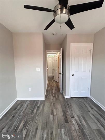 unfurnished bedroom with dark wood-type flooring and ceiling fan