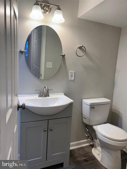 bathroom featuring vanity, hardwood / wood-style floors, and toilet