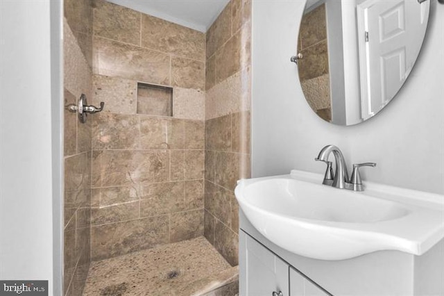 bathroom with vanity and a tile shower