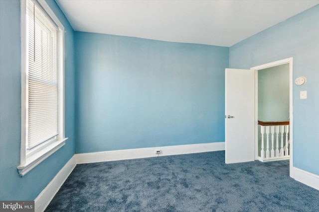 spare room featuring carpet flooring and baseboards