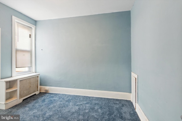 carpeted spare room with radiator and baseboards