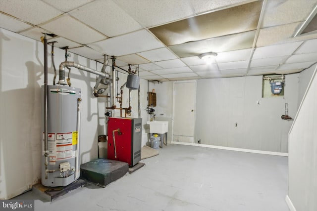 finished below grade area with gas water heater, a paneled ceiling, and a heating unit