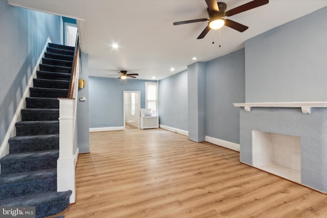 unfurnished living room with light wood-type flooring and ceiling fan