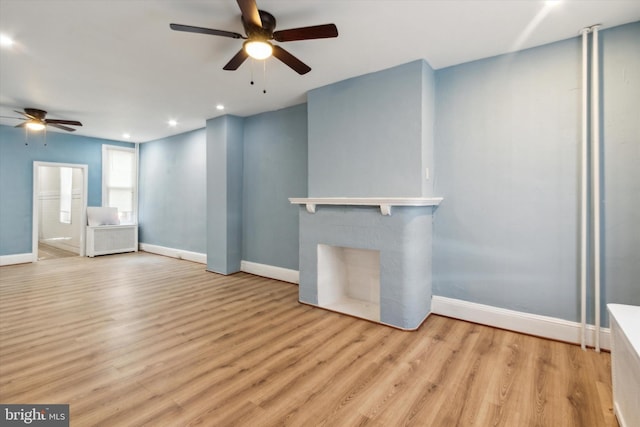 unfurnished living room featuring baseboards, a ceiling fan, light wood-type flooring, a fireplace, and recessed lighting