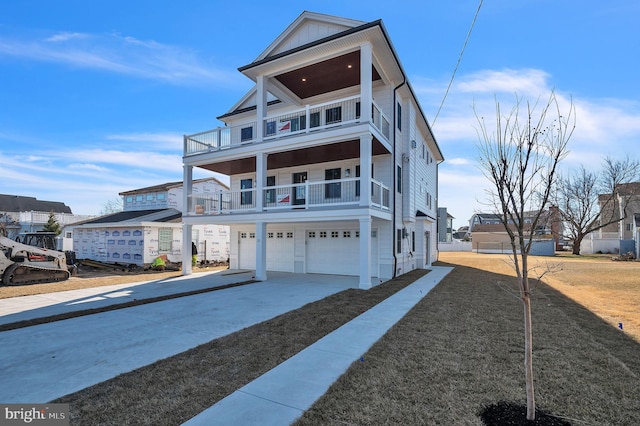 view of front of home featuring board and batten siding, driveway, a balcony, and an attached garage