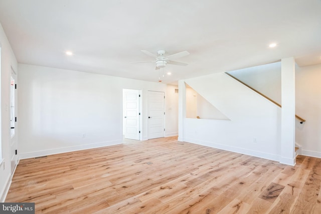 unfurnished living room featuring light wood-style floors, stairs, baseboards, and recessed lighting