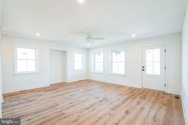 interior space with light wood-style floors, plenty of natural light, and baseboards