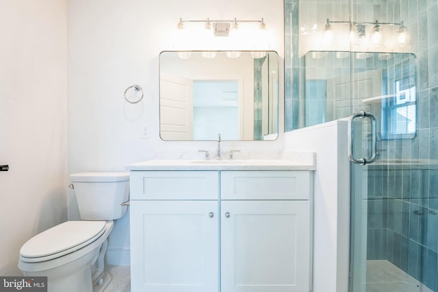 bathroom with a stall shower, vanity, and toilet