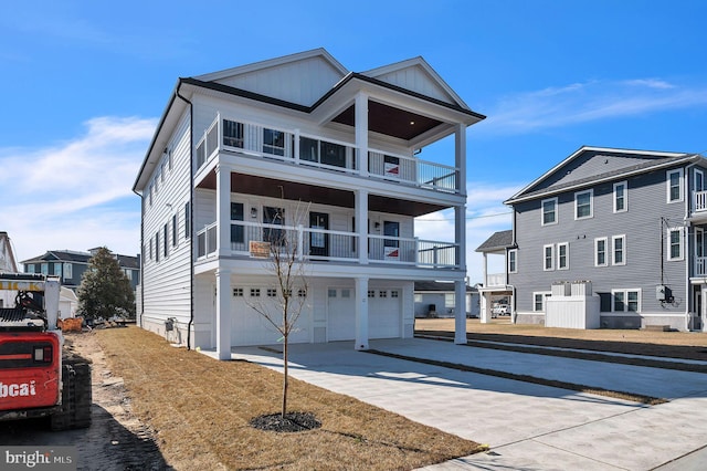 view of front of home with driveway, board and batten siding, an attached garage, and a balcony