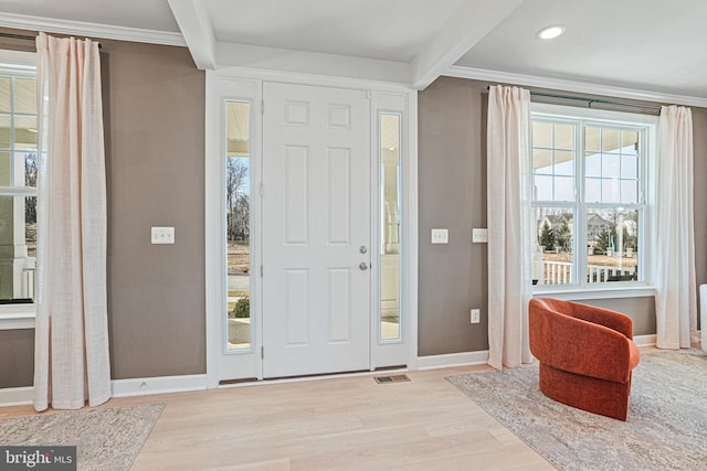 foyer featuring hardwood / wood-style floors, crown molding, and beamed ceiling