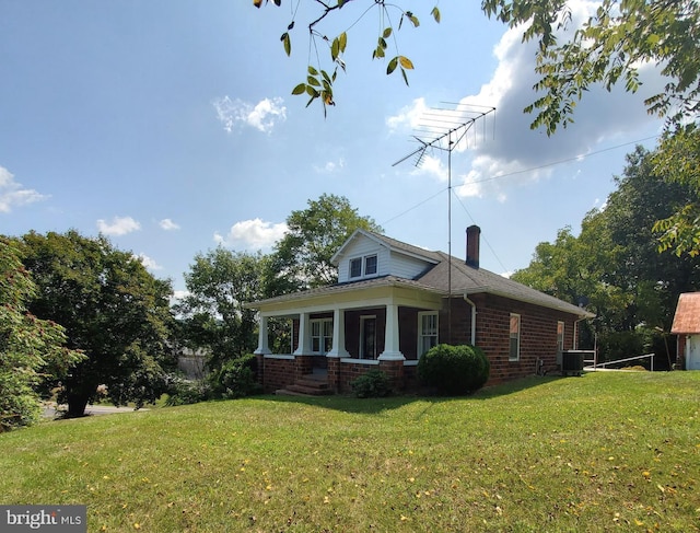 view of home's exterior featuring brick siding, a lawn, a chimney, and central AC unit