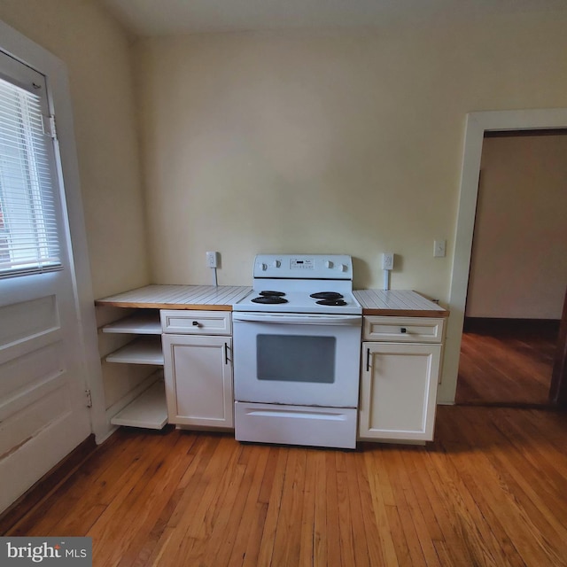 kitchen with electric stove, light wood-style flooring, and white cabinets