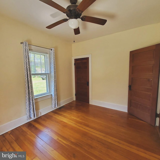 unfurnished room with baseboards and wood finished floors