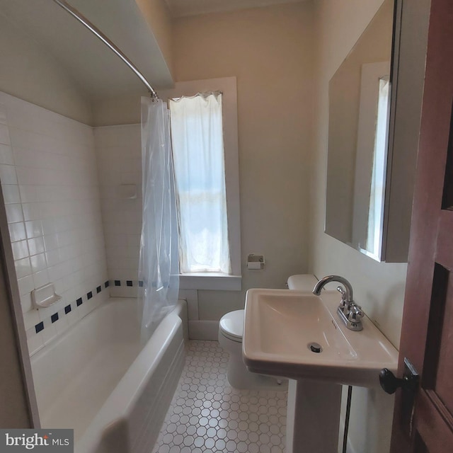 full bath with toilet, shower / bath combo with shower curtain, a sink, and tile patterned floors