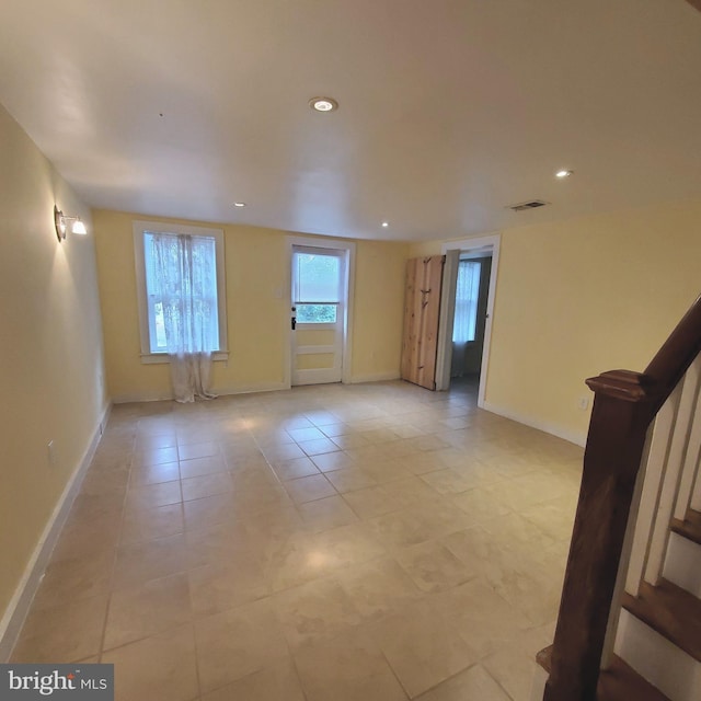 spare room featuring light tile patterned floors, recessed lighting, visible vents, stairway, and baseboards