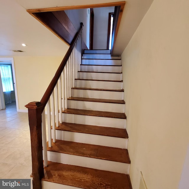 staircase featuring tile patterned flooring, visible vents, and baseboards