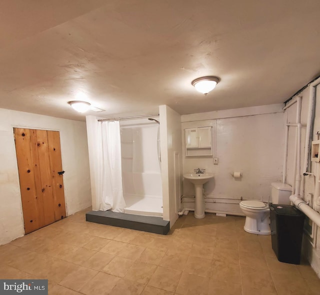 bathroom featuring a sink, a shower stall, and toilet