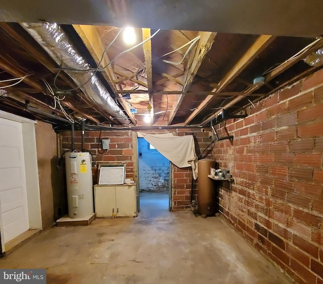 unfinished below grade area featuring brick wall and water heater