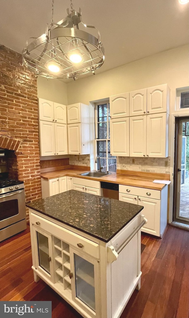 kitchen featuring appliances with stainless steel finishes, dark wood-style flooring, white cabinetry, and a sink