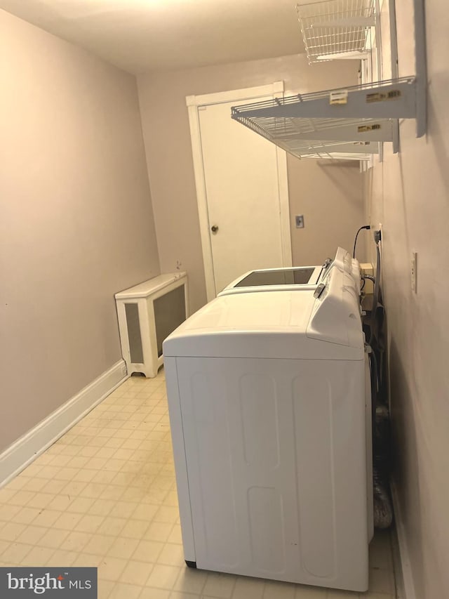 laundry area with laundry area, separate washer and dryer, and baseboards