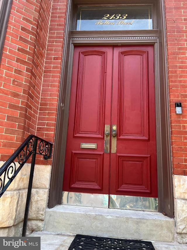 view of exterior entry featuring brick siding