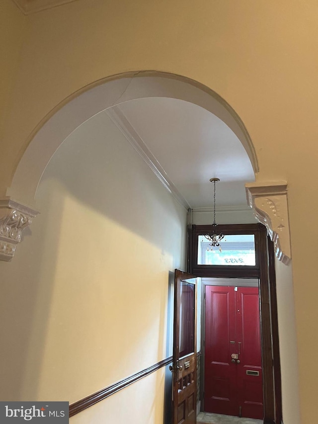 foyer entrance with arched walkways and ornamental molding