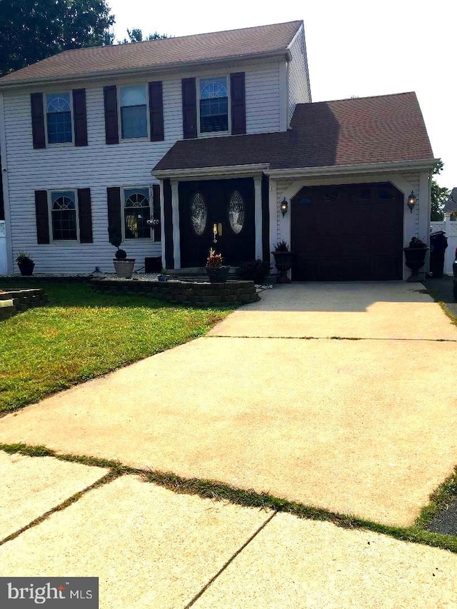 view of front of house with a garage and a front lawn