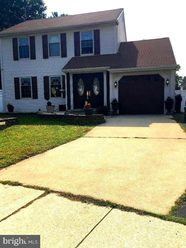 view of front of home with driveway, a front lawn, and an attached garage