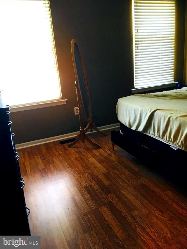 bedroom with dark hardwood / wood-style flooring